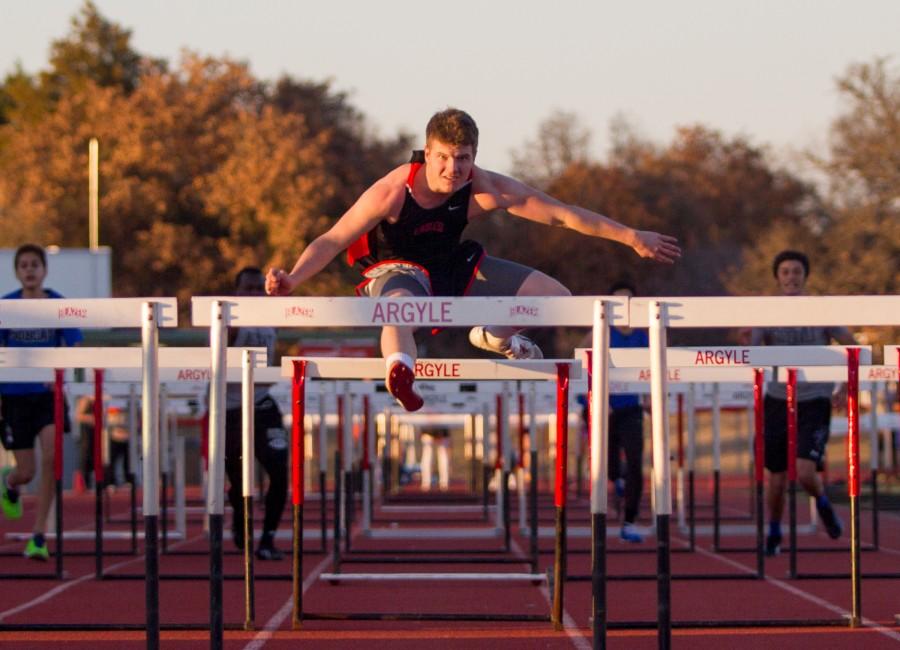 Jake Weaver clears the hurdle in order to pass his opponents.