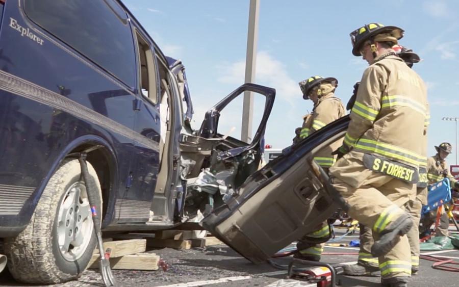 Fire fighters pull apart the doors of the crashed vehicles to save the victims trapped inside on May 20, 2015 during the Shattered Dreams program at Argyle High School. (Greg Royar)