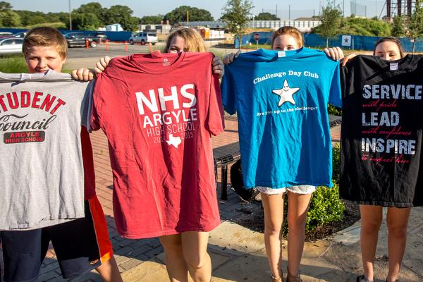 Students hold up different club shirts (6-4-15) at Argyle High School June 3, 2015 in Argyle, TX. (Caleb Miles / The Talon News)