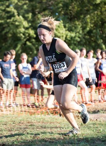 Freshman Faith Stapleton races through the mud pit at Denton Compass on Sept. 4 during a girls' varsity run. (Annabel Thorpe)