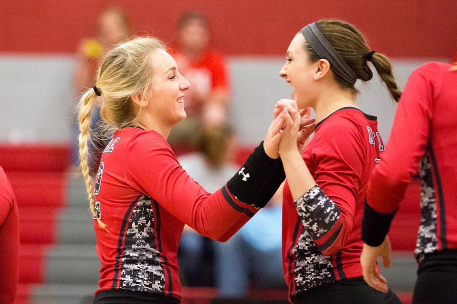 Senior Meagan Dealy and junior Halee Van Poppel cheer after scoring a kill against Gainesville at Argyle High School on 10/23/15 in Argyle, Texas. (Photo by Caleb Miles  / The Talon News)