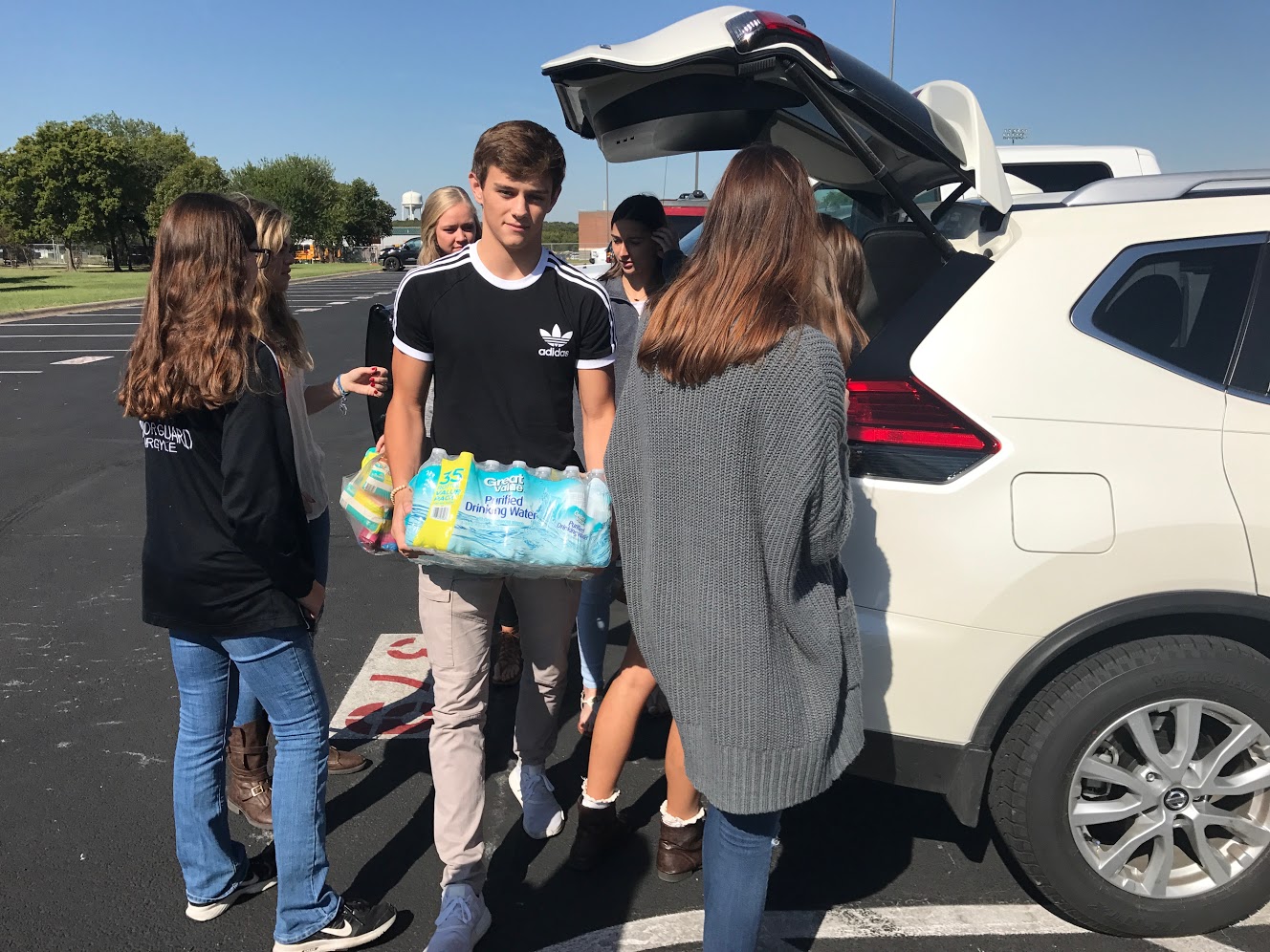 Students transport donated water into the school. (Stacy Short/The Talon News)