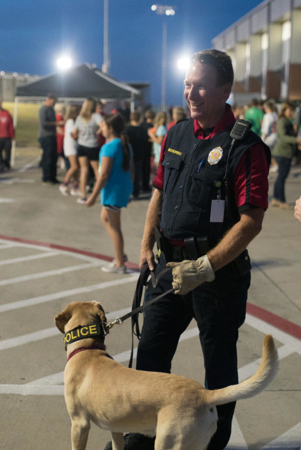 AISD K-9 Officer Robert Mastropiero leads Kiro, the schools drug dog, through the Homecoming Carnival at Argyle High School in Argyle, Texas, on Oct. 18, 2017. (Stacy Short / The Talon News)