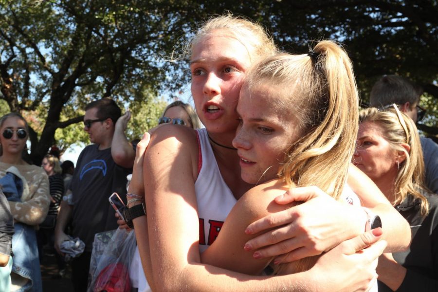 Senior Lanie Rodgers and junior Allie Johnson embrace following the University Interscholastic League (UIL) cross country state tournament. Rodgers led her team to state and has built a community within the program. (Jaclyn Harris | The Talon News)