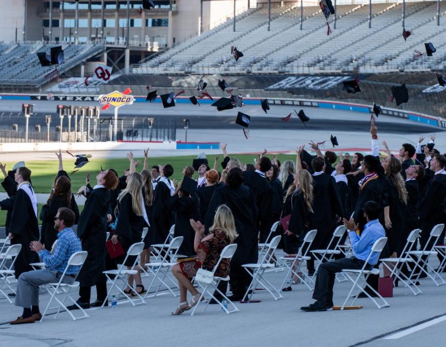 Seniors sit on the track six feet apart from each other while waiting for their turn to walk across stage at the Texas Motor Speedway in Fort Worth, Texas on May 18, 2020. (Alex Daggett / The Talon News)