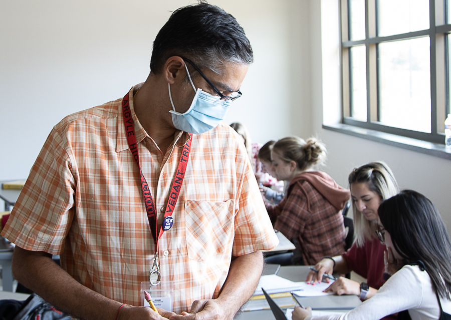 Vedant Tripathi walks around the room to monitor his pre-calculus class. (Sam Mykel | The Talon News)