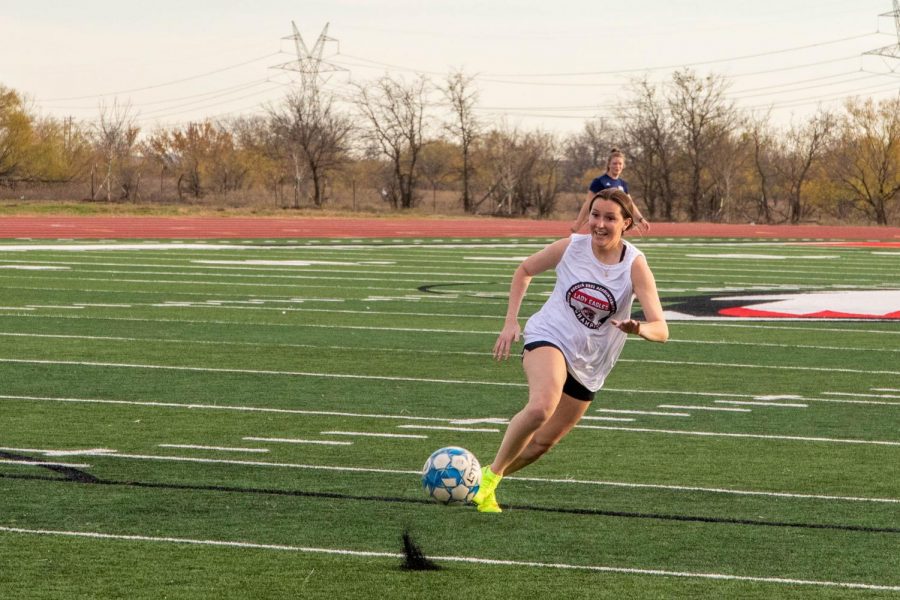Senior Brynlee Gasperson chases after the soccer ball after kicking it towards the goal. 