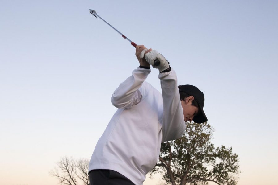 Junior Brett Walsh prepares for upcoming golf season by practicing after school.