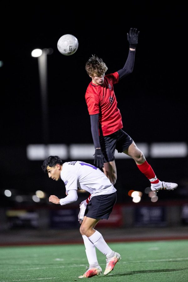Argyle senior Jayden Broadhurst leaps atop a Decatur opponent to headbutt a ball in a soccer game at Eagle Stadium. Argyle went on to win the game 4-1 against Decatur. 