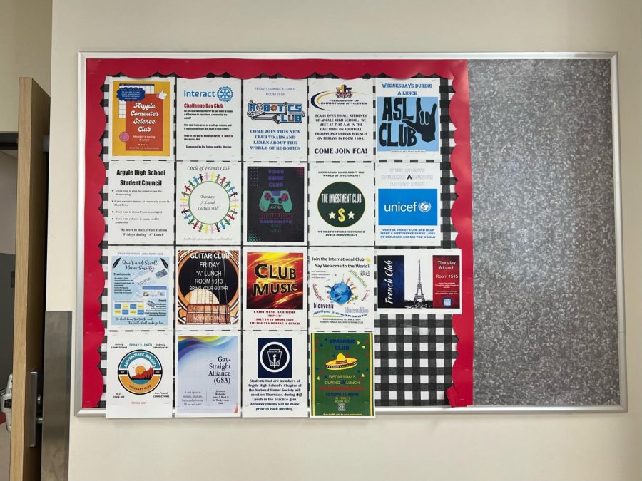 A hallway board features clubs available for students to join. Clubs have scheduled days to meet during mega lunch each week.