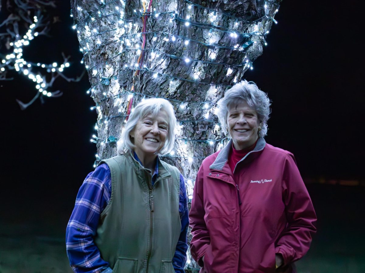  Jan Deatherage and Barbara Nunneley standing in front of their light up Pecan tree in Bartonville, Texas, taken on Dec. 19, 2023.