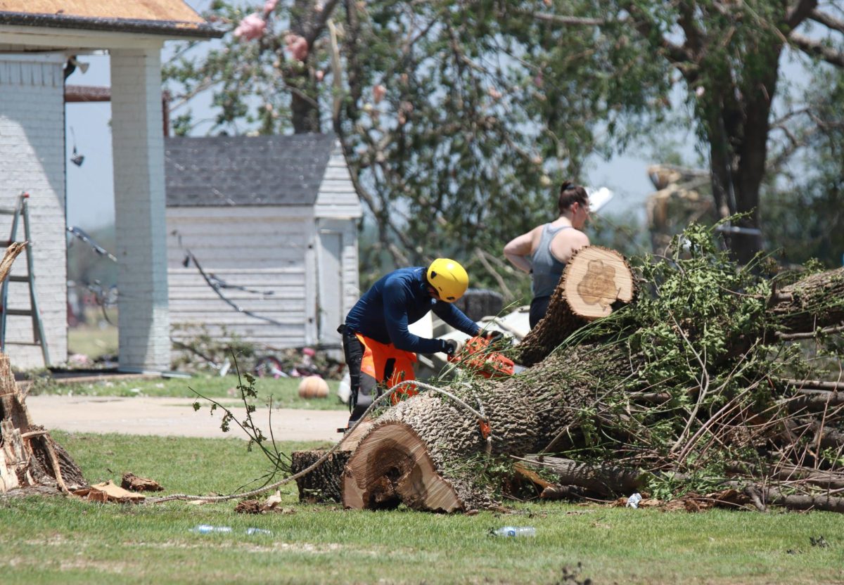 Residents begin to clear tree debris after a tornado hits their home. Taken May 26, 2024. 