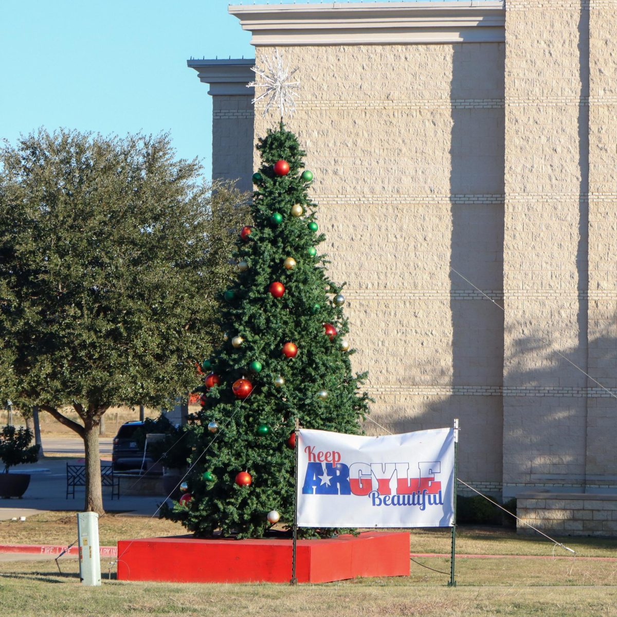 Keep Argyle Beautiful's banner stands in front of the towering Christmas tree at the Argyle United Methodist Church in preparation for the Argyle Christmas Tree Lighting Festival. Taken Dec. 2, 2024. 